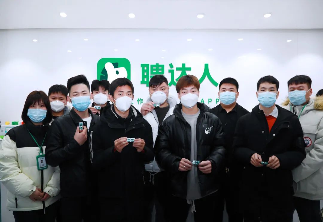 收到防疫药品的求职者与公司员工合影留念